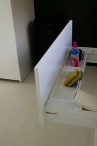 Détail du meuble sous évier, avec rangement supérieur et poubelle tri-sélectif en bas.